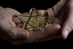 Hands holding a yellow fabric Star of David